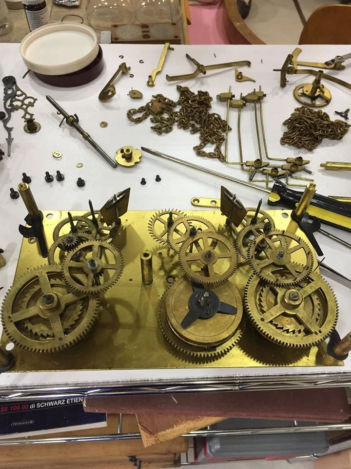 Complesso sistema di ingranaggi e catene di un orologio antico smontato per restauro
