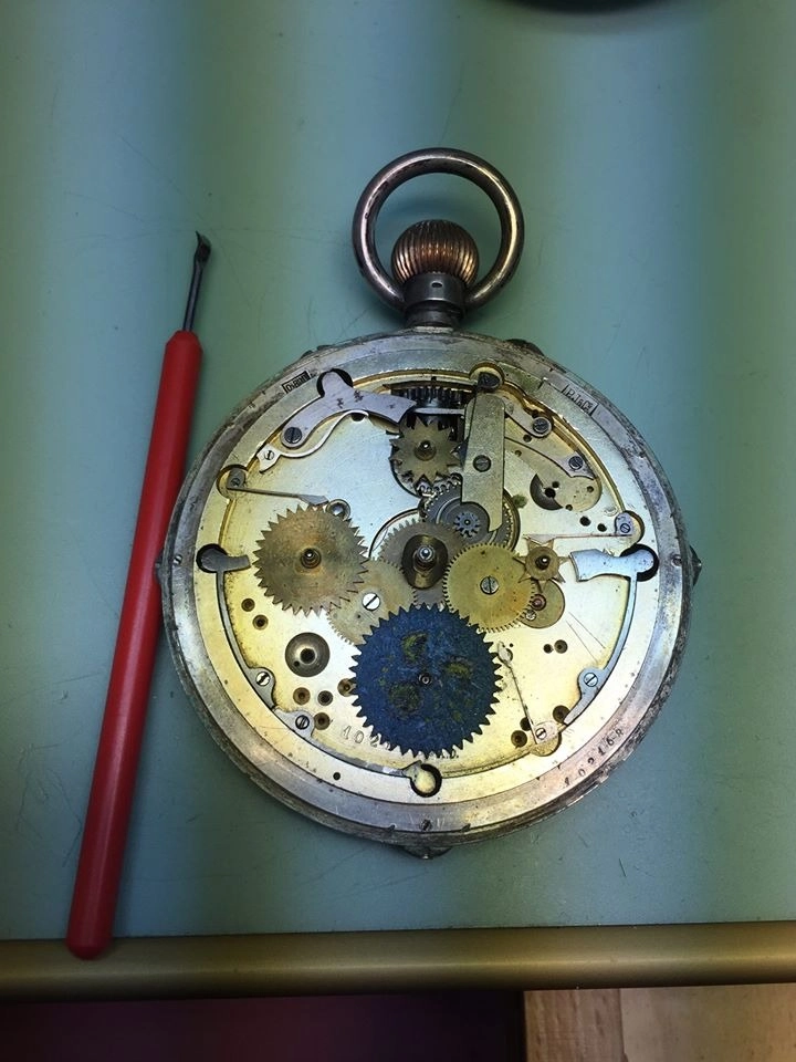 Movimento meccanico dorato di un antico orologio da tasca aperto sul banco da lavoro
