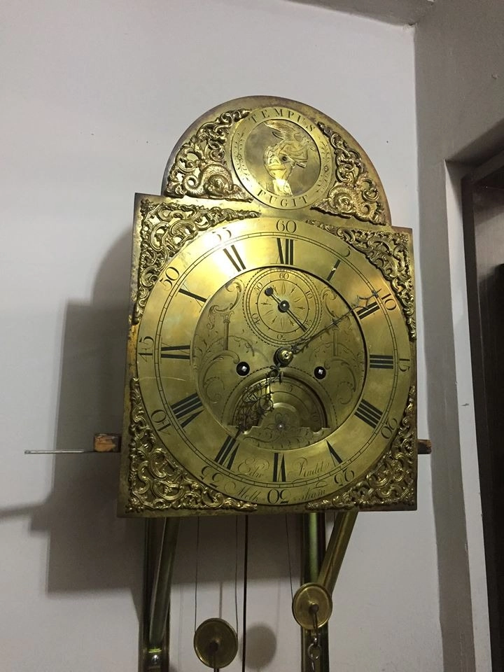Orologio antico a pendolo con grande quadrante decorato in ottone e numeri romani