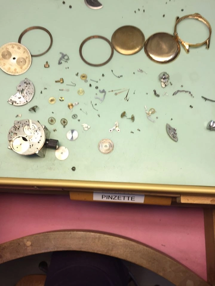 Componenti di un orologio meccanico completamente smontato sul banco da lavoro