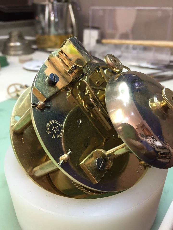 Dettaglio del meccanismo di suoneria di un orologio antico con campana metallica